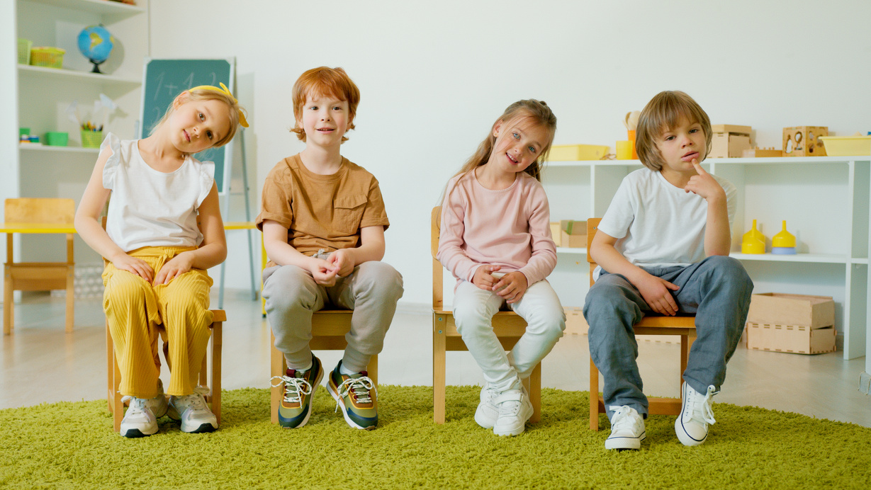 Children Sitting on Wooden Chairs 