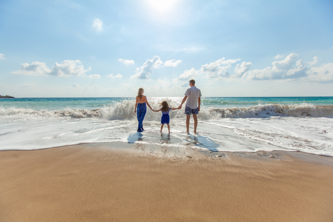 Parents and Child Holding Hands at the Beach